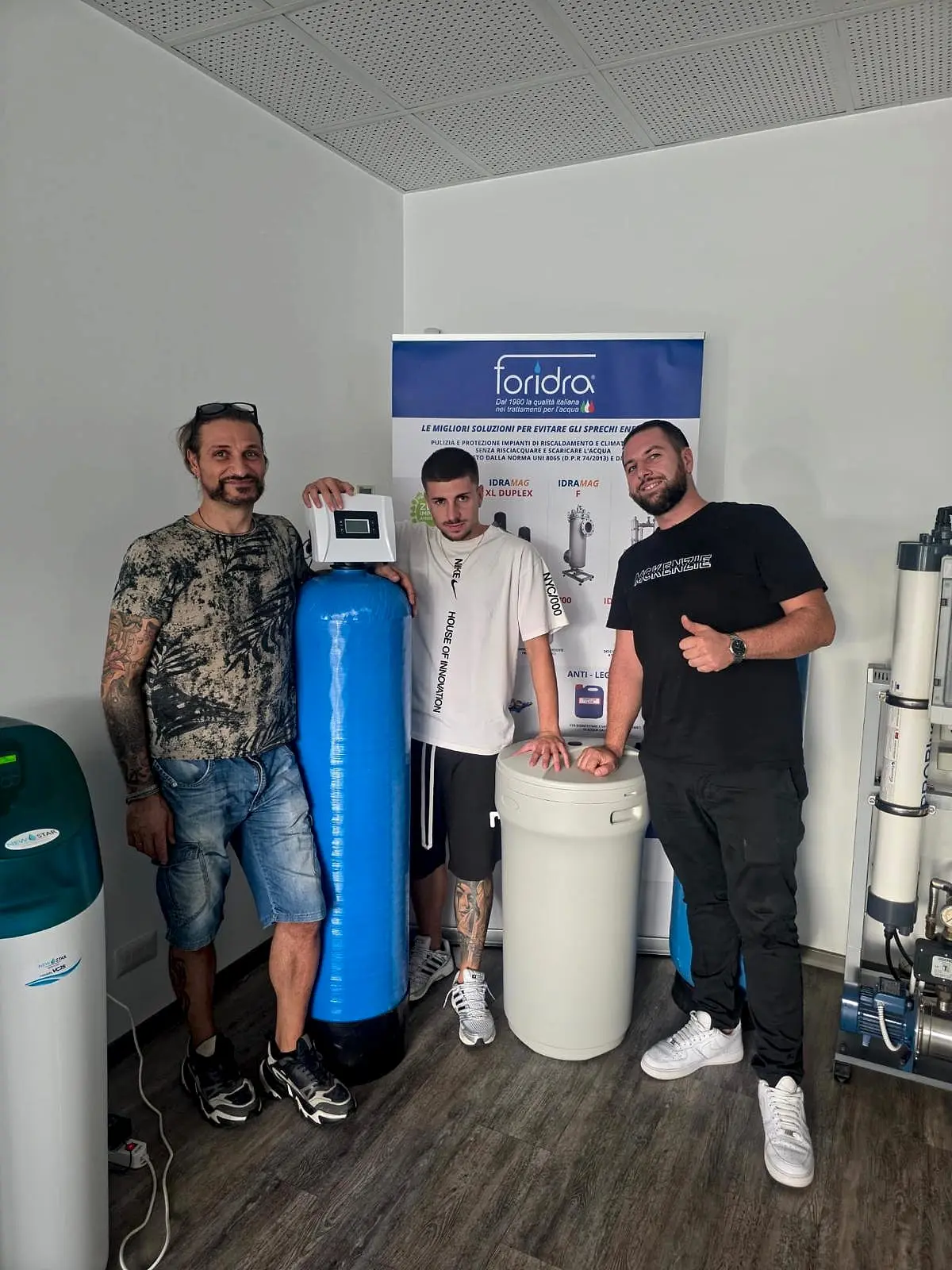 Tre persone della squadra accanto agli addolcitori e ai sistemi di trattamento dell’acqua Foridra