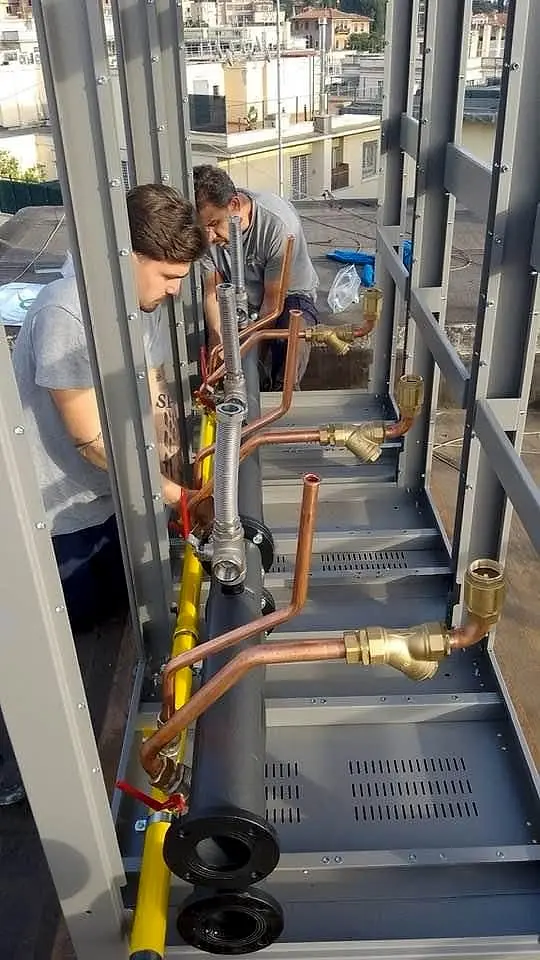 Un tecnico al lavoro sulle tubazioni in rame di un impianto